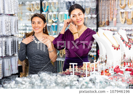 Two happy women are choosing different jewelry in jewelry store Two happy women are choosing different jewelry in jewelry store 107946196