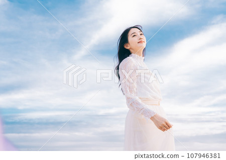 Woman portrait on blue sky background Woman portrait on blue sky background 107946381
