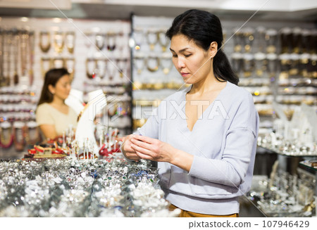 Young adult woman choosing rings in store 107946429