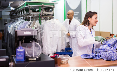 Experienced woman working in dry cleaner 107946474