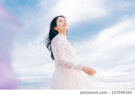 Woman portrait on blue sky background 107946560