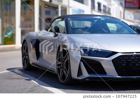 Side view of a silver luxury sport car parked on a street 107947225
