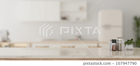 A luxury white marble kitchen countertop with a burred background of a modern white kitchen. 107947790