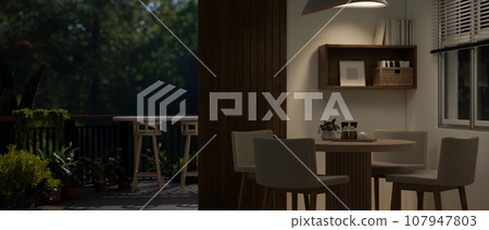 A modern dining room with a balcony with a beautiful nature view at night. A modern dining room with a balcony with a beautiful nature view at night. 107947803