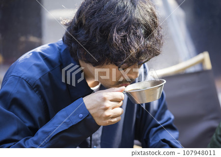 一名男子早上在豪華露營設施中用 Sierra 杯喝咖啡 107948011