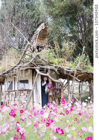 A woman standing at the entrance of a small hut A woman standing at the entrance of a small hut 107948488