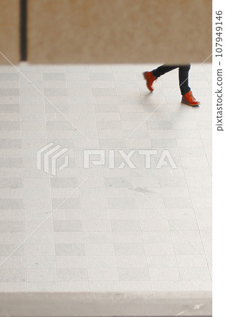 People walking on tiles in front of the station 107949146