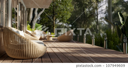 Side view of a beautiful deck with cosy round wicker armchairs and a beautiful green nature view. Side view of a beautiful deck with cosy round wicker armchairs and a beautiful green nature view. 107949609