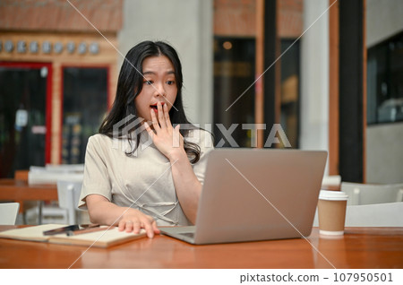 An amazed Asian female freelancer looked at her laptop screen with a surprising face An amazed Asian female freelancer looked at her laptop screen with a surprising face 107950501