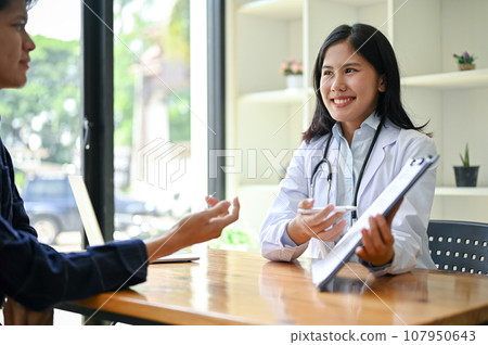 A female doctor is in the examination room with a patient for a medical checkup 107950643