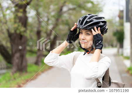 young woman wearing a cycling helmet 107951190