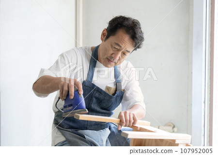 Man using sander DIY at home Man using sander DIY at home 107952005