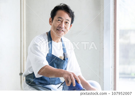 Man using sander DIY at home Man using sander DIY at home 107952007