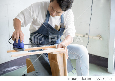 Man using sander DIY at home Man using sander DIY at home 107952008