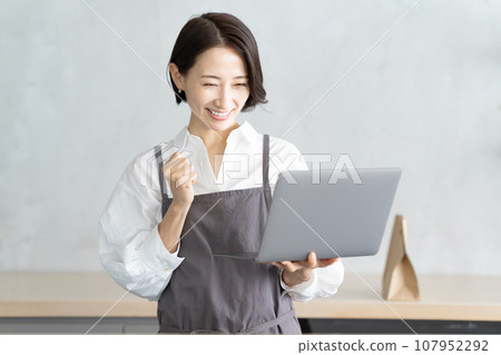 A cafe clerk checking orders on a computer 107952292