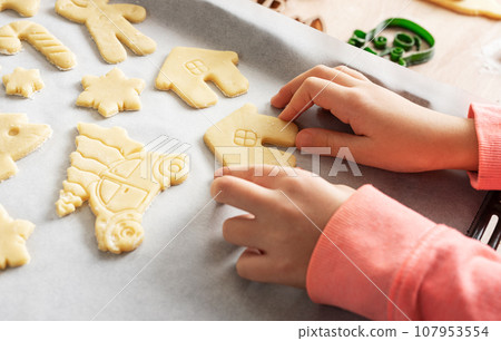 Children's hands with gingerbread cookies on wooden background Children's hands with gingerbread cookies on wooden background 107953554