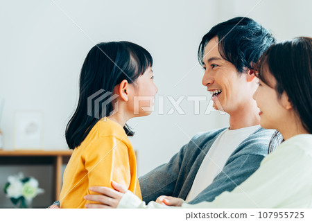 A young family relaxing in the living room　 107955725