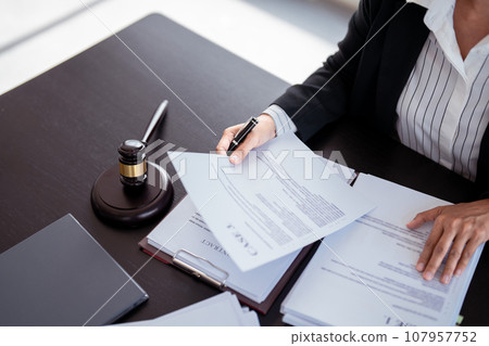 Lawyer businesswoman holding document to reading lawsuit and checking about financial business data while analysis about legislation agreement and terms data of business contract in law firm 107957752