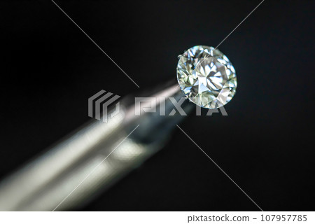 Diamond in jeweler tweezers Diamond in jeweler tweezers 107957785