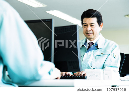 Middle-aged male businessman wearing work clothes working in the office Middle-aged male businessman wearing work clothes working in the office 107957936