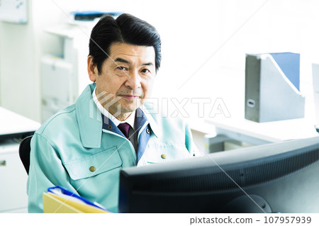 Middle-aged male businessman wearing work clothes working in the office 107957939