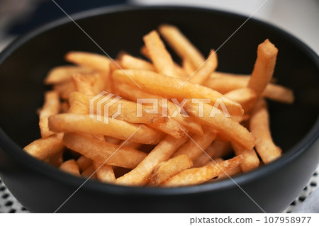 The Salted French fries in white bowl on a wooden tray The Salted French fries in white bowl on a wooden tray 107958977
