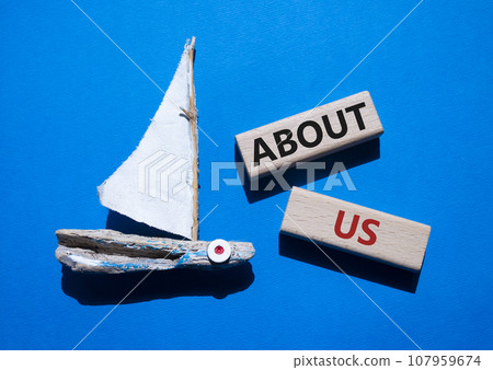 About us symbol. Concept word About us on wooden blocks. Beautiful blue background with boat. Business and About us concept. Copy space 107959674