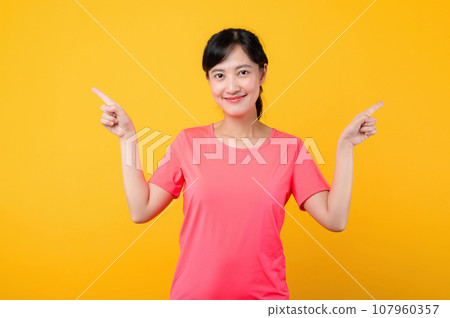 Portrait beautiful young asian sports fitness woman happy smile wearing pink sportswear posing exercise training workout isolated on yellow studio background. wellbeing and healthy lifestyle concept. Portrait beautiful young asian sports fitness woman happy smile wearing pink sportswear posing exercise training workout isolated on yellow studio background. wellbeing and healthy lifestyle concept. 107960357