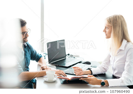 Business meeting. Client consulting. Confident business woman, real estate agent, financial advisor explaining details of project or financial product to client in office Business meeting. Client consulting. Confident business woman, real estate agent, financial advisor explaining details of project or financial product to client in office 107960490