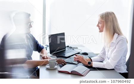 Business meeting. Client consulting. Confident business woman, real estate agent, financial advisor explaining details of project or financial product to client in office 107960492