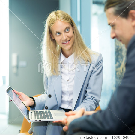 Business meeting. Client consulting. Confident business woman, real estate agent, financial advisor explaining details of project or financial product to client in office 107960493