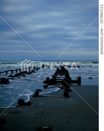 A dilapidated pier in the dark sea A dilapidated pier in the dark sea 107960521