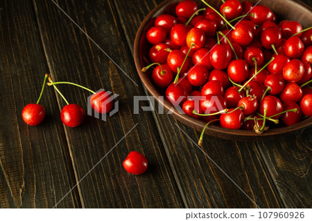 Cherries in a vintage plate on a dark table. Cherry for dessert. Sweet berries for the diet Cherries in a vintage plate on a dark table. Cherry for dessert. Sweet berries for the diet 107960926