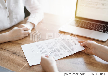 Businesswoman lawyer pointing into contract special points admitting something for colleague or client at the wooden desk in office. Business people teamwork and partnership, meeting concept Businesswoman lawyer pointing into contract special points admitting something for colleague or client at the wooden desk in office. Business people teamwork and partnership, meeting concept 107961041