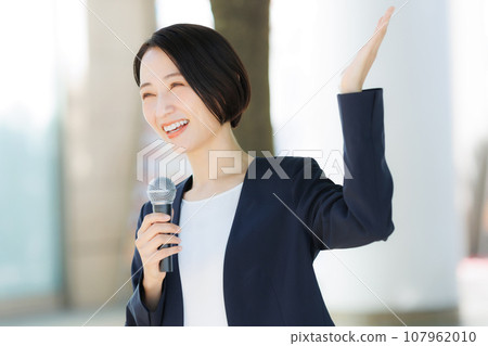 A woman talking with a microphone A woman talking with a microphone 107962010