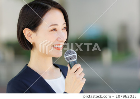 A woman talking with a microphone A woman talking with a microphone 107962015