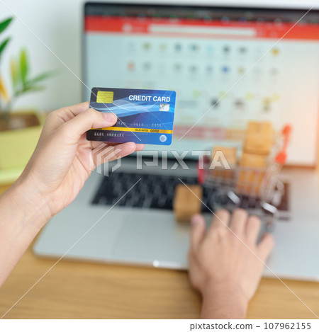 woman hand holding credit card and using laptop with mobile phone for online shopping while making order. Marketplace platform website, technology, ecommerce, shipping delivery and online payment woman hand holding credit card and using laptop with mobile phone for online shopping while making order. Marketplace platform website, technology, ecommerce, shipping delivery and online payment 107962155