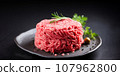 Fresh minced meat ground beef on a black plate. 107962800