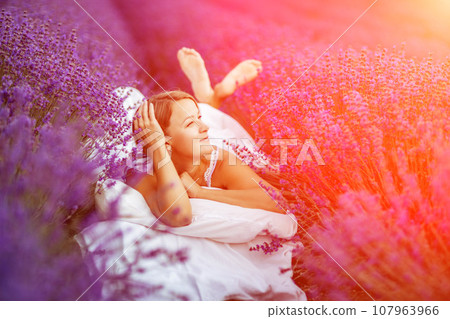 Woman lavender field. A middle-aged woman lies in a lavender field and enjoys aromatherapy. Aromatherapy concept, lavender oil, photo session in lavender Woman lavender field. A middle-aged woman lies in a lavender field and enjoys aromatherapy. Aromatherapy concept, lavender oil, photo session in lavender 107963966