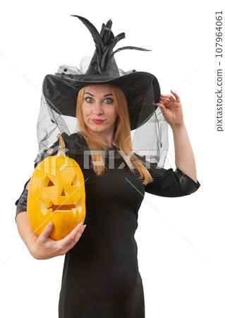Portrait of beautiful woman in a witch's hat and a jack-o'-lantern in her hands. White background Halloween party. Vertical frame 107964061