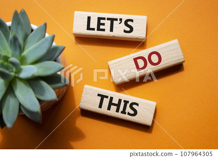 Lets do this symbol. Concept word Lets do this on wooden blocks. Beautiful orange background with succulent plant. Business and Lets do this concept. Copy space 107964305