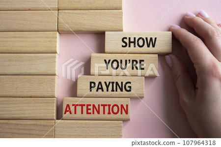 Attention symbol. Concept word Show You are Paying Attention on wooden blocks. Beautiful pink background. Businessman hand. Business and Show You are Paying Attention concept. Copy space 107964318