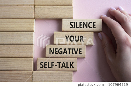 Silence your negative self-talk symbol. Concept words Silence your negative self-talk on wooden blocks. Doctor hand. Beautiful pink background. Psychology concept. Copy space. 107964319