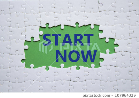 Start now symbol. White puzzle with words Start now. Beautiful green background. Business and Start now concept. Copy space. 107964329