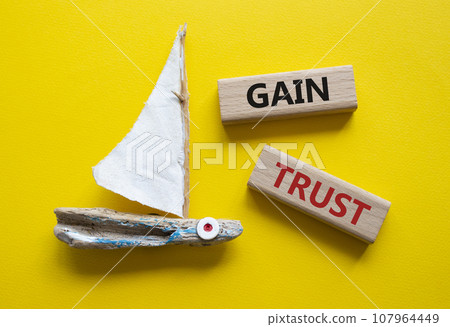 Gain trust symbol. Wooden blocks with words Gain trust. Beautiful yellow background with boat. Business and Gain trust concept. Copy space. Gain trust symbol. Wooden blocks with words Gain trust. Beautiful yellow background with boat. Business and Gain trust concept. Copy space. 107964449