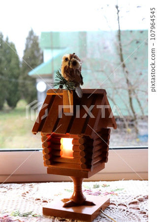 A wooden fairy-tale house lamp with a toy owl A wooden fairy-tale house lamp with a toy owl 107964545
