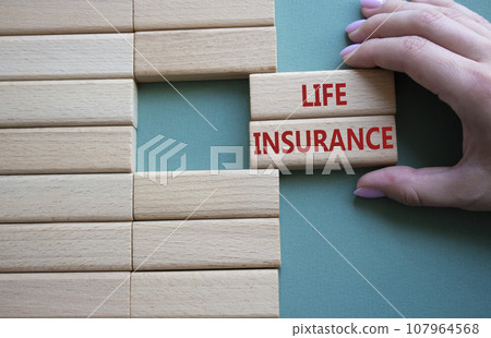 Life insurance symbol. Concept word Life insurance on wooden blocks. Businessman hand. Beautiful grey green background. Business and Life insurance concept. Copy space 107964568