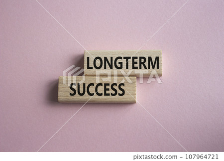 Longterm success symbol. Wooden blocks with words Longterm success. Beautiful pink background. Business and Longterm success concept. Copy space. 107964721