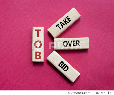 TOB - Take Over Bid. Wooden cubes with words TOB. Beautiful red background. Business and TOB concept. Copy space. TOB - Take Over Bid. Wooden cubes with words TOB. Beautiful red background. Business and TOB concept. Copy space. 107964917