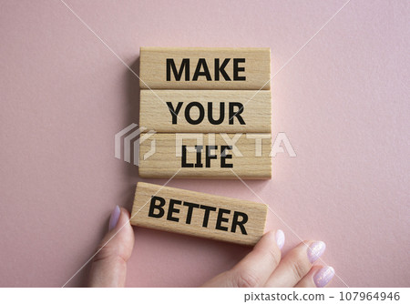 Make your Life Better symbol. Concept word Make your Life Better on wooden blocks. Beautiful pink background. Businessman hand. Business and Make your Life Better concept. Copy space 107964946